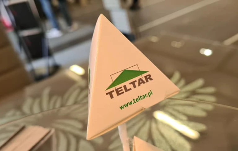 logo Teltar na trójkątnej podstawce